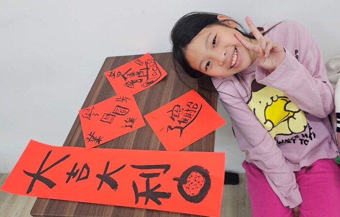完成春聯作品後，學生開心展示成果，分享迎接新年的祝福圖片