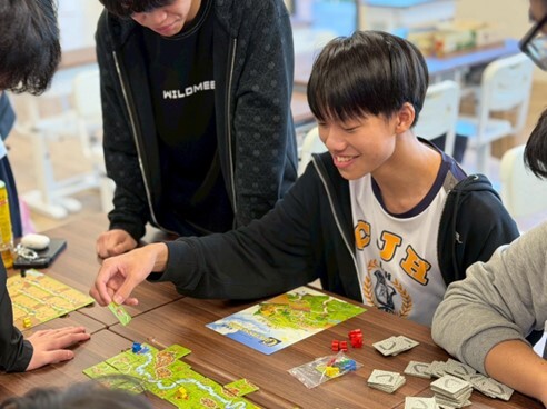 桌遊社學生運用策略和團隊溝通來進行遊戲互動圖片